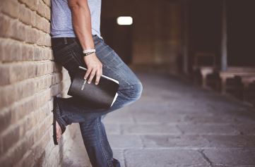 man leaning against a wall with the bible in his hand