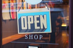 front door to a business with sign that says open