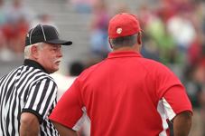 coach on game day standing with referee